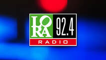 Logo von Radio Lora, dunkelblauer Hintergrund LORA in weißer Schrift in grünem Quadrat, 92,4 weiße Schrift in schwarzem Quadrat
